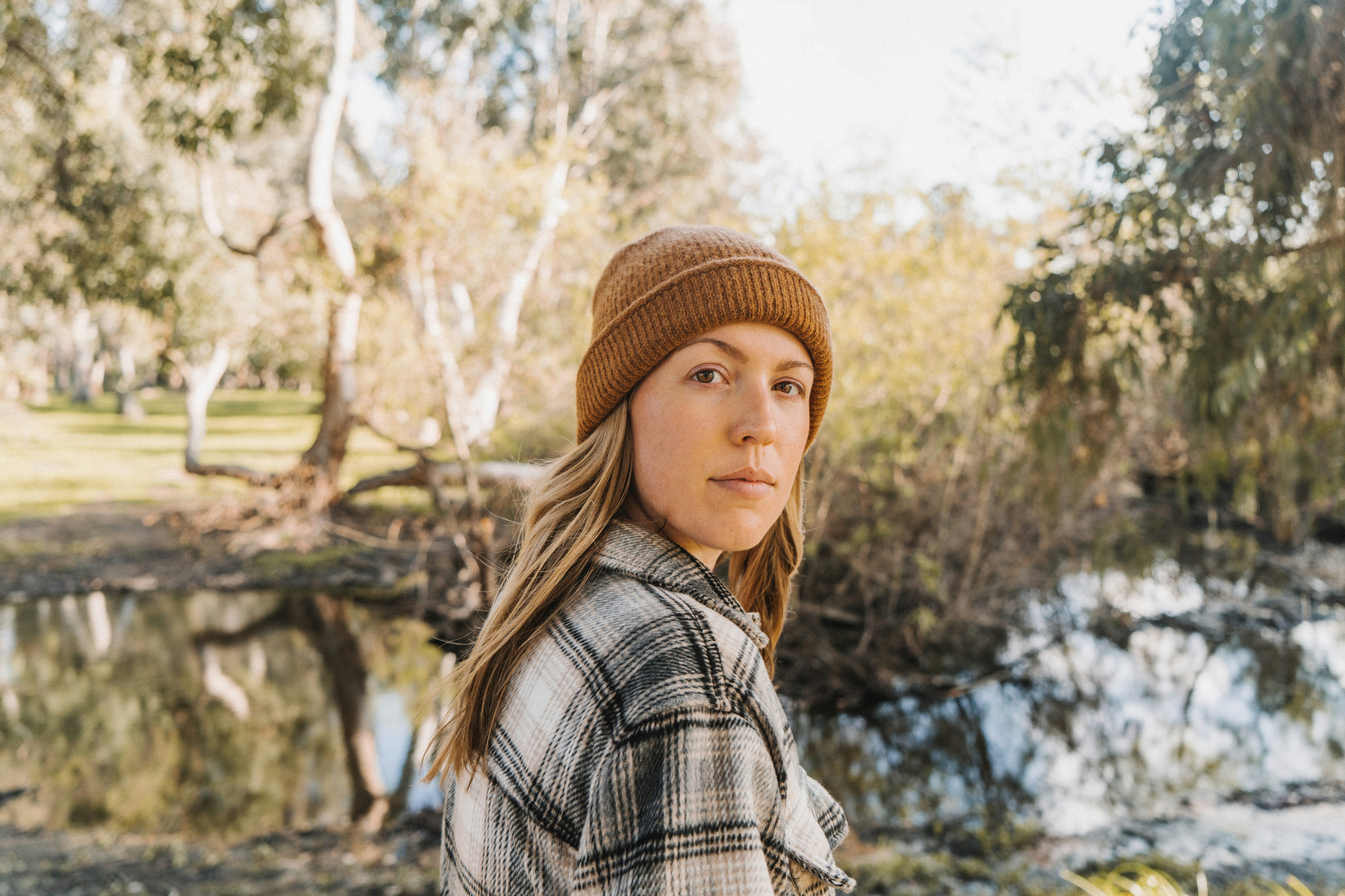 woman in brown knit cap and plaid shirt